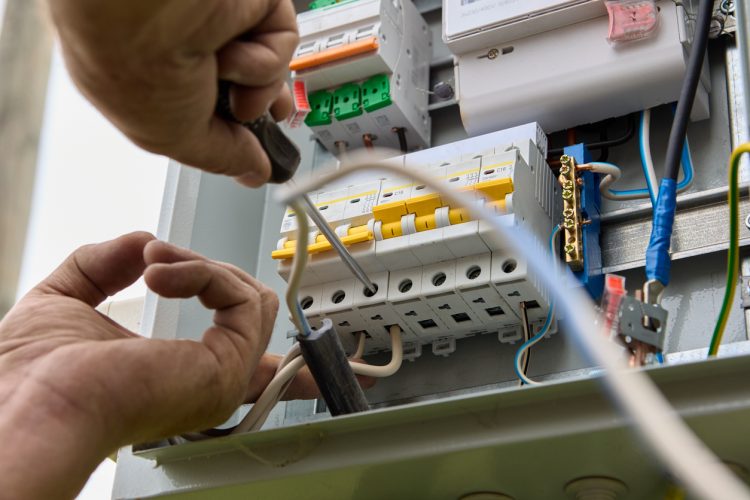 Electric distribution board consumer unit with fuse box or circuit breaker, electrical work to install new panel.